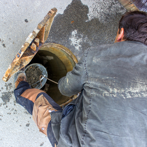 A worker cleaning a sewer.