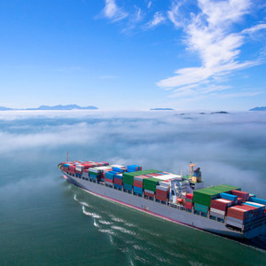 Aerial view of a container ship sailing through the fog.