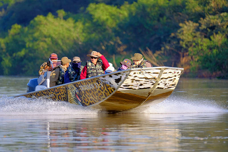 Tourists, pilot and guide on a boat excursion, Pantanal, Brazil.