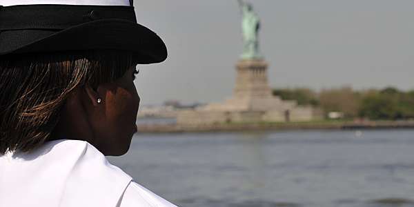 US Navy female sailor gazing at the statue of liberty in New York, USA. 