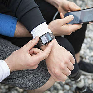 Overhead view gay couple preparing smart watch, checking fitness app on smart phone