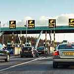 Cars queuing to pass through the barriers on a Toll road.
