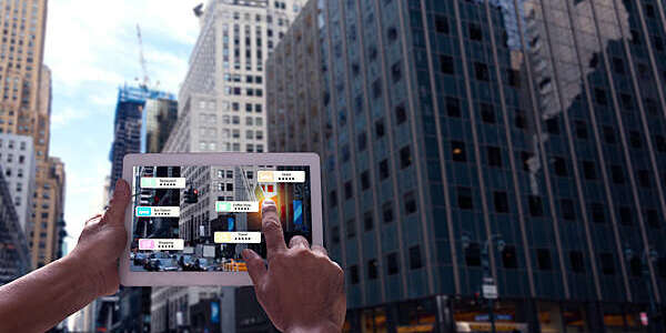 Hand holding a tablet with an augmented reality app showing nearby shops and eateries in New York City.