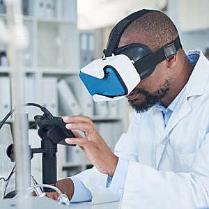 Side shot of scientist wearing a virtual reality headset as he conducts research in a laboratory.